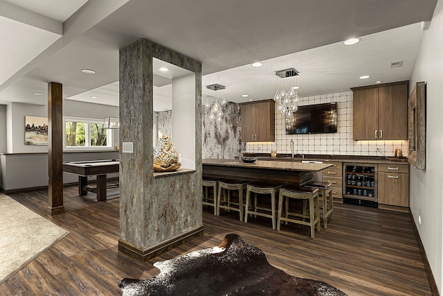 bar with wine cooler, backsplash, dark wood-type flooring, and pendant lighting