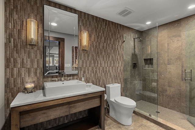 bathroom featuring tile walls, vanity, tile patterned floors, toilet, and walk in shower