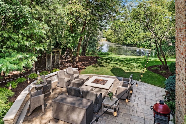 view of patio / terrace with a water view and an outdoor living space with a fire pit