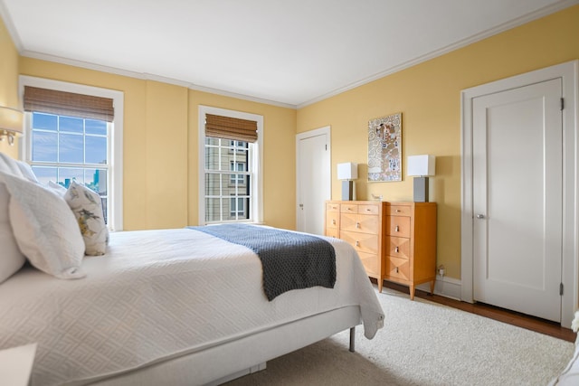 bedroom with ornamental molding and hardwood / wood-style floors