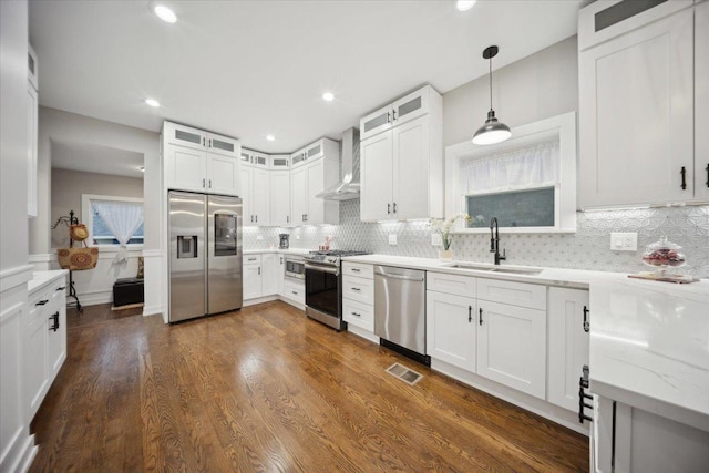 kitchen with white cabinetry, sink, wall chimney range hood, and appliances with stainless steel finishes