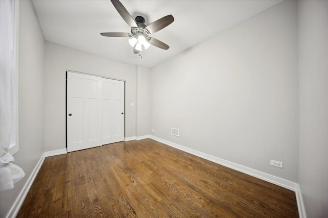 unfurnished bedroom with hardwood / wood-style floors, ceiling fan, and a closet