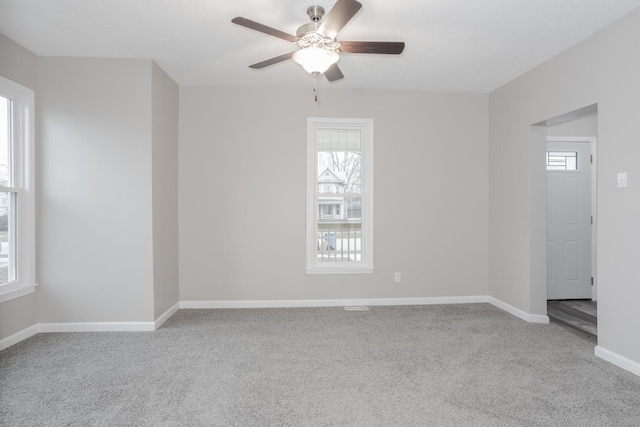 carpeted spare room with ceiling fan