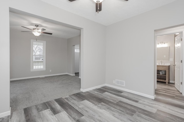 unfurnished room with ceiling fan, sink, and light hardwood / wood-style flooring