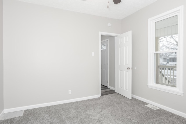 carpeted spare room with ceiling fan