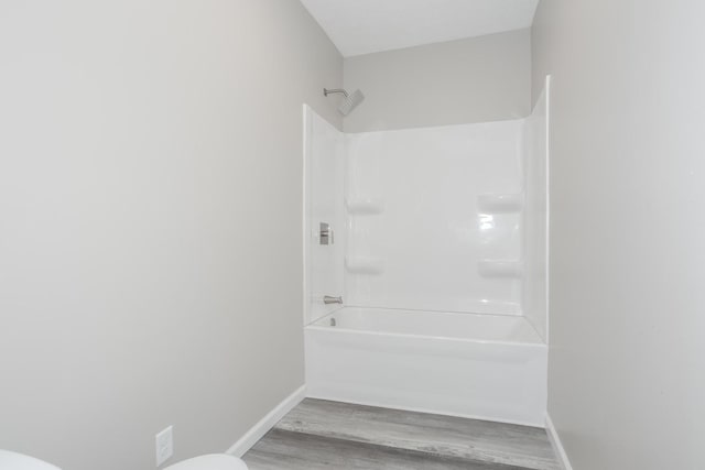 bathroom featuring hardwood / wood-style flooring, toilet, and shower / bath combination