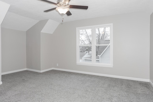 additional living space featuring lofted ceiling, ceiling fan, a textured ceiling, and carpet flooring