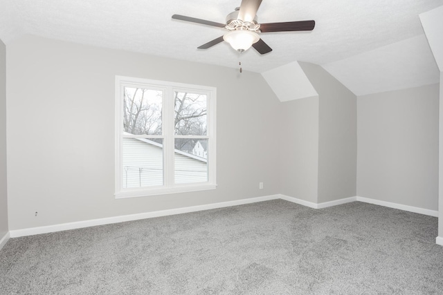 bonus room with ceiling fan, lofted ceiling, carpet flooring, and a textured ceiling