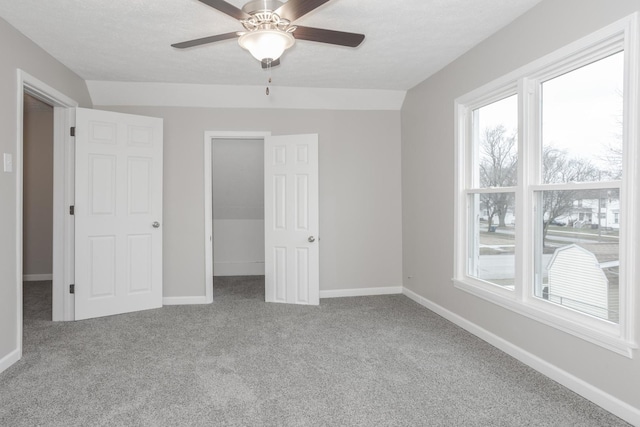 unfurnished bedroom featuring ceiling fan, carpet, and a textured ceiling