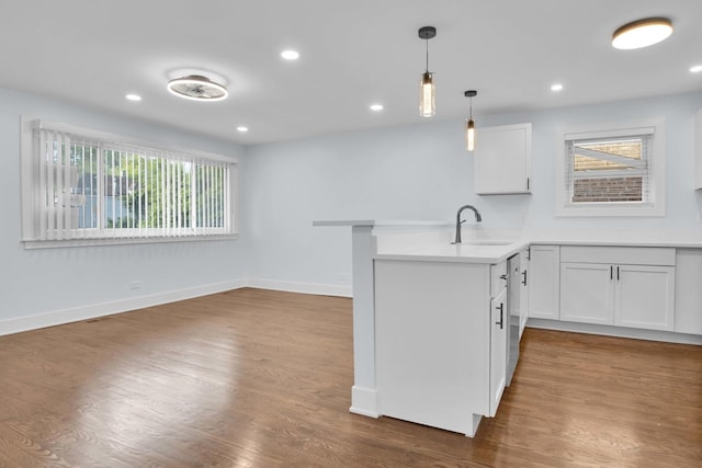 kitchen featuring white cabinets, pendant lighting, dark hardwood / wood-style flooring, and kitchen peninsula