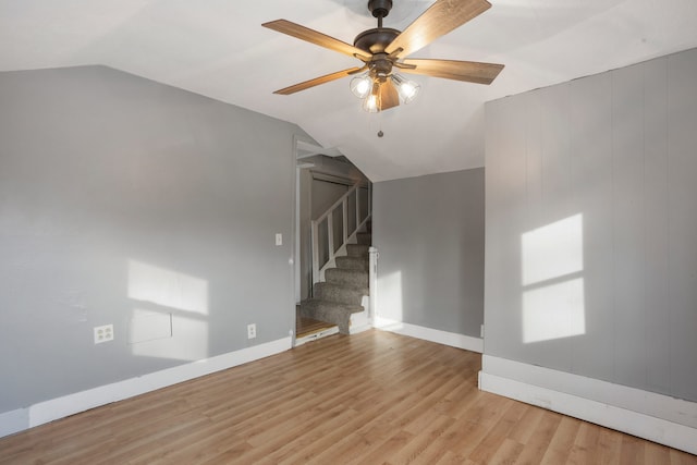 unfurnished living room with light hardwood / wood-style floors, ceiling fan, and vaulted ceiling