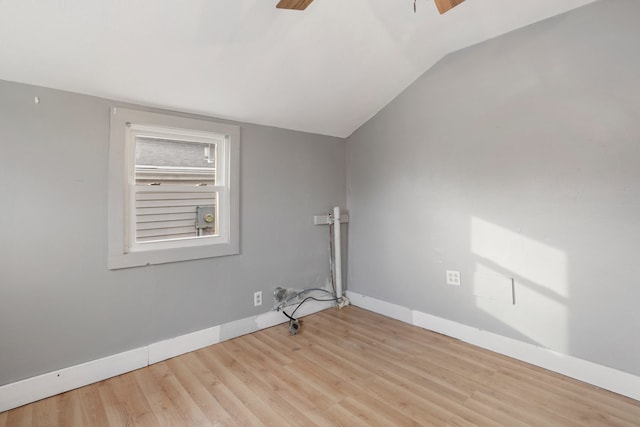 spare room with light hardwood / wood-style floors and vaulted ceiling