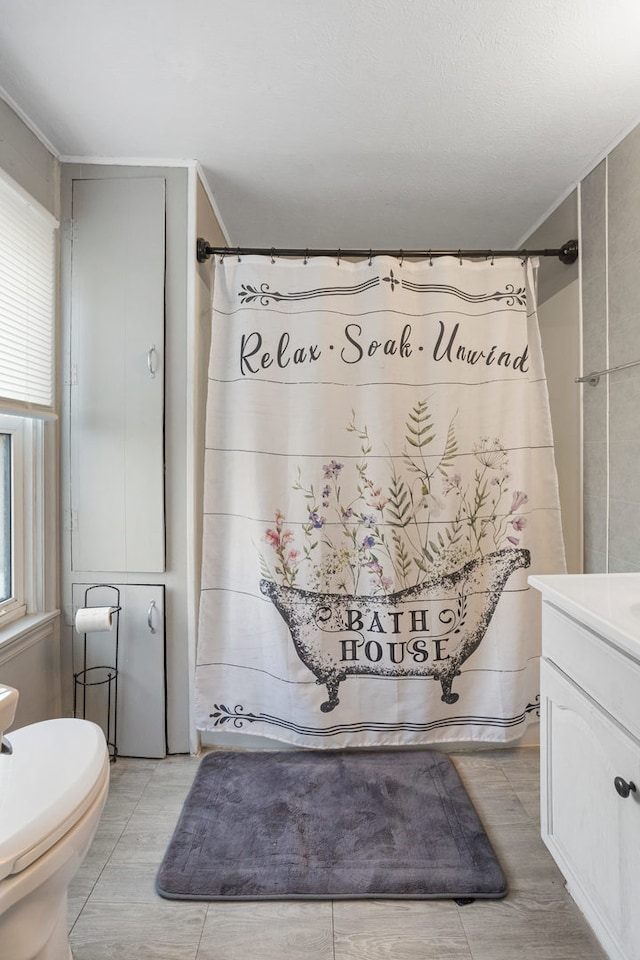 bathroom with toilet, vanity, tile patterned floors, and ornamental molding