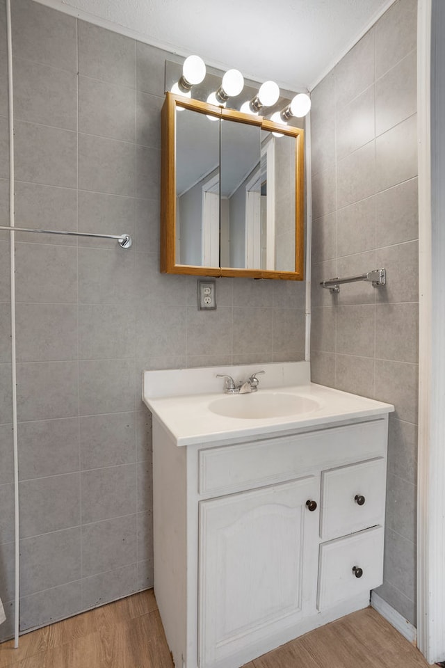 bathroom with vanity, tile walls, and wood-type flooring