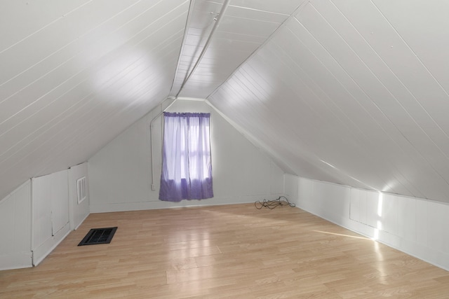 additional living space featuring vaulted ceiling and light hardwood / wood-style flooring