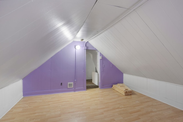 bonus room featuring lofted ceiling and light hardwood / wood-style flooring