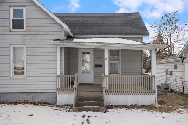 snow covered property entrance featuring a porch