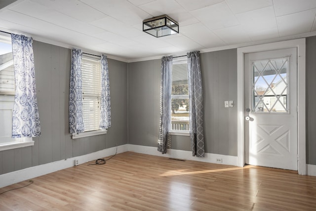 entrance foyer featuring ornamental molding and light hardwood / wood-style flooring