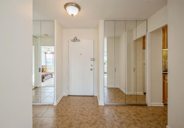 foyer featuring ceiling fan and light tile patterned floors