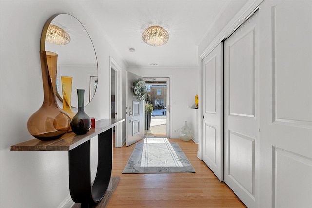 entryway featuring ornamental molding and light hardwood / wood-style floors