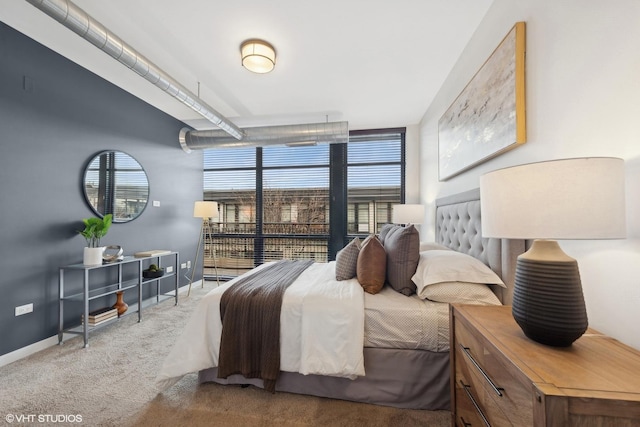 bedroom with floor to ceiling windows and light carpet