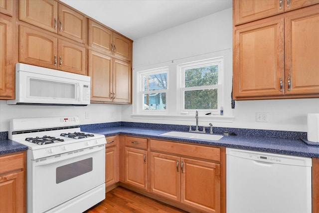 kitchen featuring white appliances, light hardwood / wood-style floors, and sink