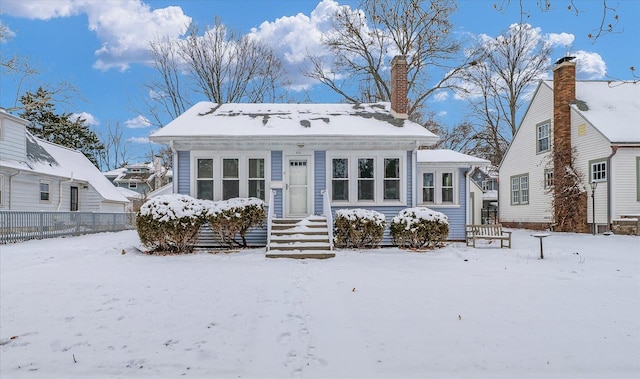 view of snow covered back of property