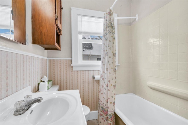 full bathroom featuring toilet, shower / bathtub combination with curtain, and sink