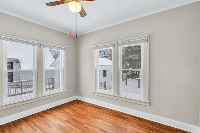 spare room with hardwood / wood-style floors, ceiling fan, and a healthy amount of sunlight