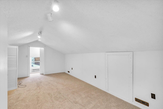 bonus room with light carpet, a textured ceiling, and vaulted ceiling