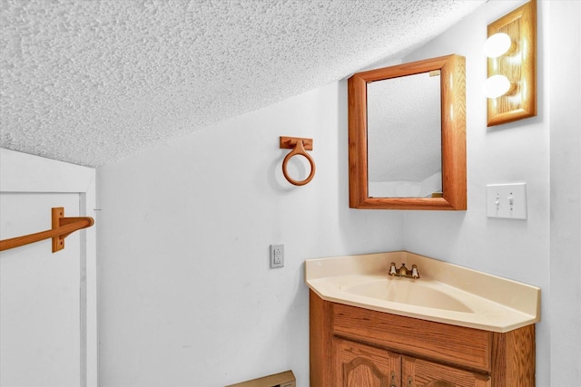 bathroom featuring vanity, a textured ceiling, and vaulted ceiling