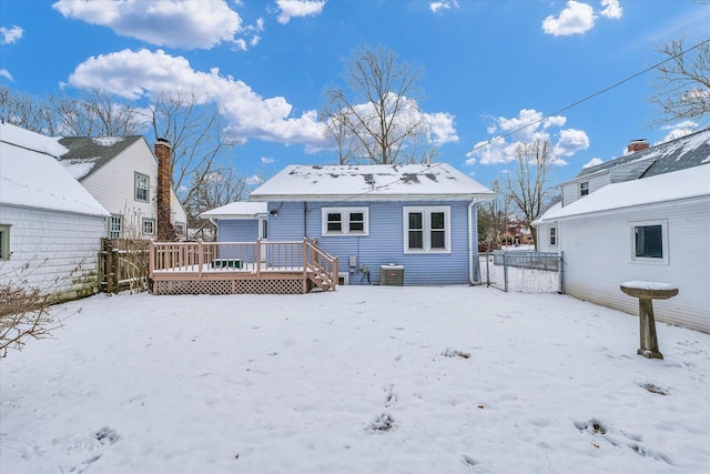 snow covered back of property featuring a deck