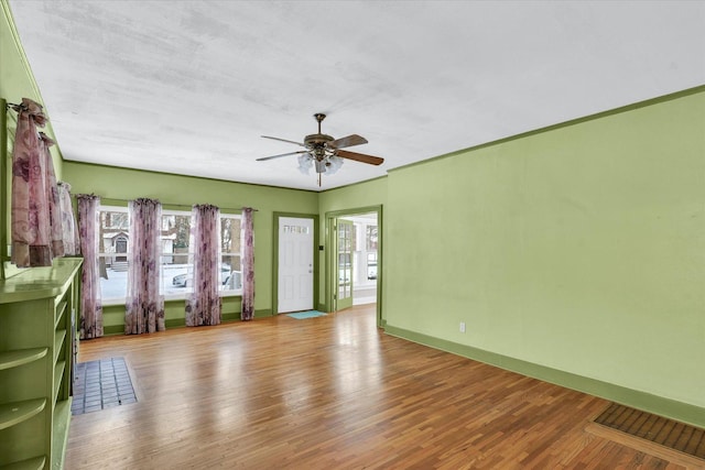 empty room with ceiling fan and light hardwood / wood-style floors