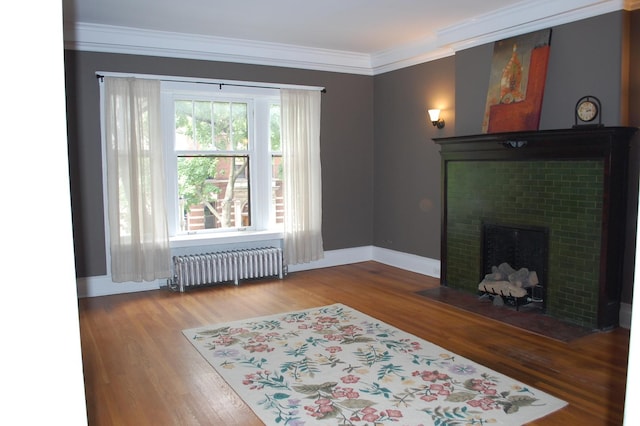 living room featuring wood-type flooring, crown molding, and radiator