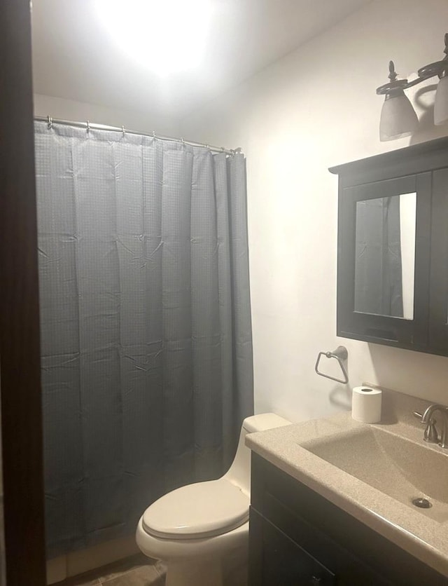 bathroom with vanity, toilet, and curtained shower