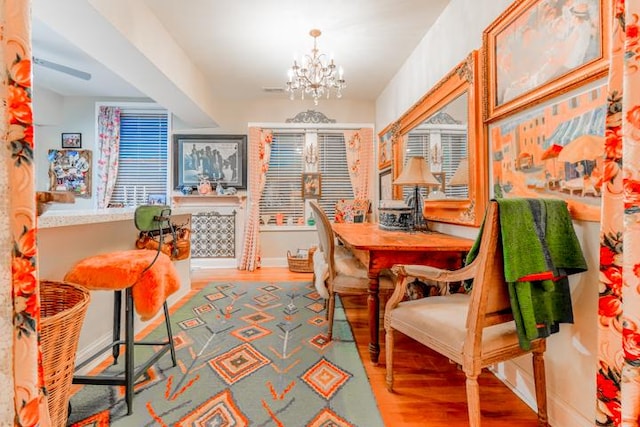 dining area featuring wood-type flooring and a notable chandelier