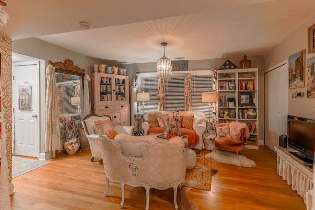 living area featuring a notable chandelier and light wood-type flooring