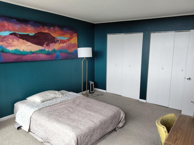 bedroom featuring carpet and two closets