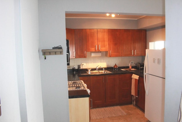 kitchen with decorative backsplash, sink, white fridge, and light tile patterned floors