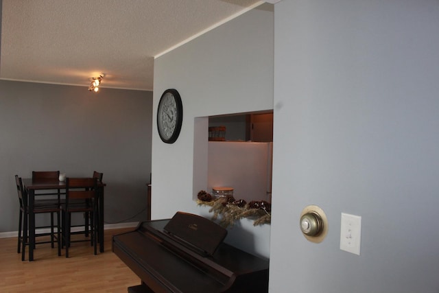 misc room with light hardwood / wood-style flooring and a textured ceiling