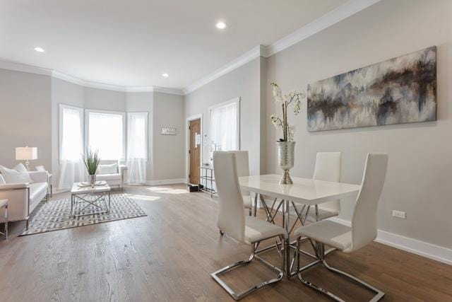 dining room featuring wood-type flooring and crown molding