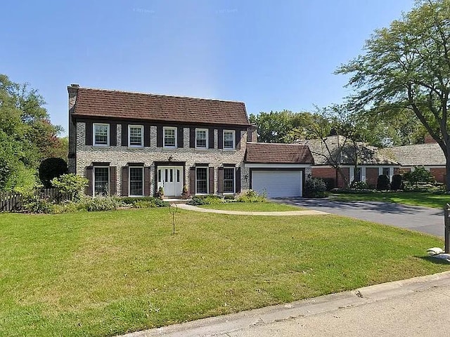 colonial-style house with a garage and a front lawn