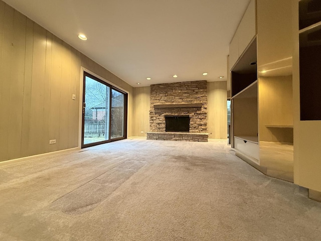 unfurnished living room featuring carpet flooring and a stone fireplace