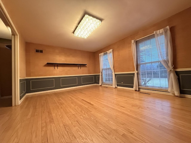 unfurnished living room with light hardwood / wood-style floors and a notable chandelier