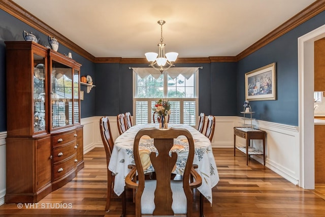 dining space with a chandelier, dark wood-type flooring, and crown molding