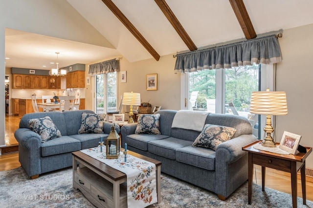 living room featuring hardwood / wood-style flooring, beam ceiling, high vaulted ceiling, and an inviting chandelier