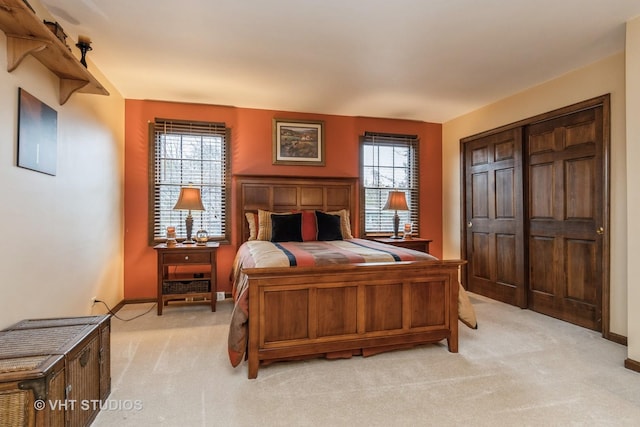 carpeted bedroom featuring multiple windows and a closet