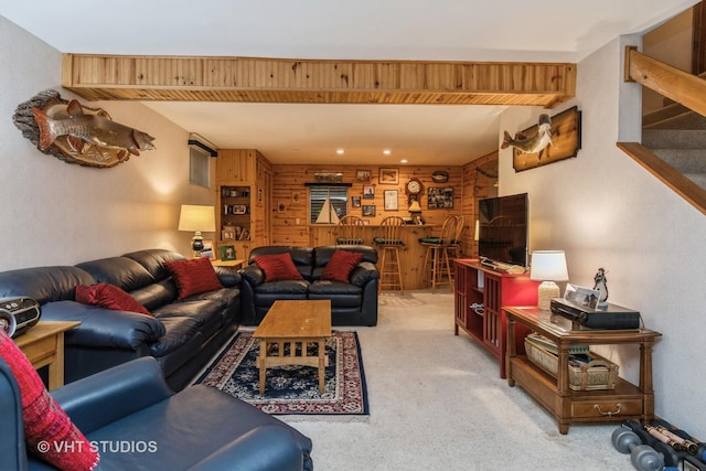 carpeted living room featuring bar and wooden walls