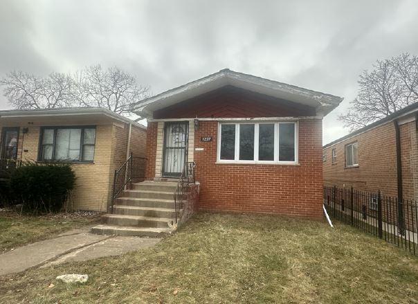 bungalow-style home with a front yard