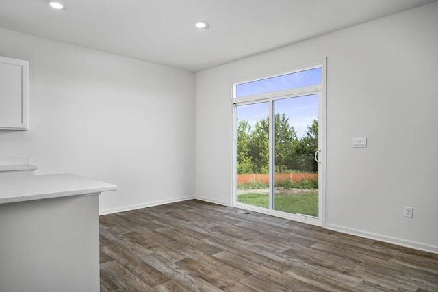 unfurnished dining area with dark wood-type flooring